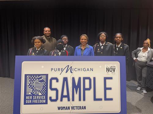  Students and others posing with new license plate revealed